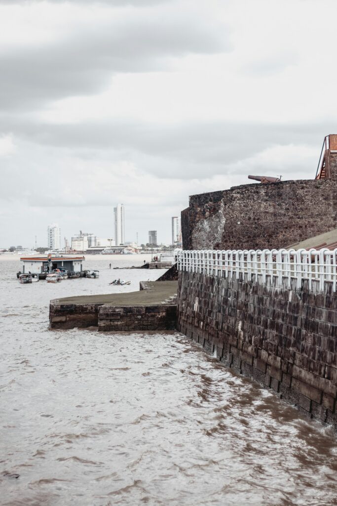 Historic stone walls on Bel&eacute;m's riverfront (orla), with the city behind, by Kaw&ecirc; Rodrigues