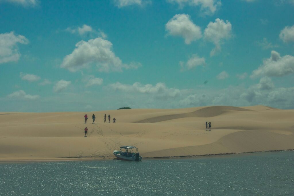 Visitors and boats on a dune-backed shore near Parna&iacute;ba, Piau&iacute;, by Javier Collarte