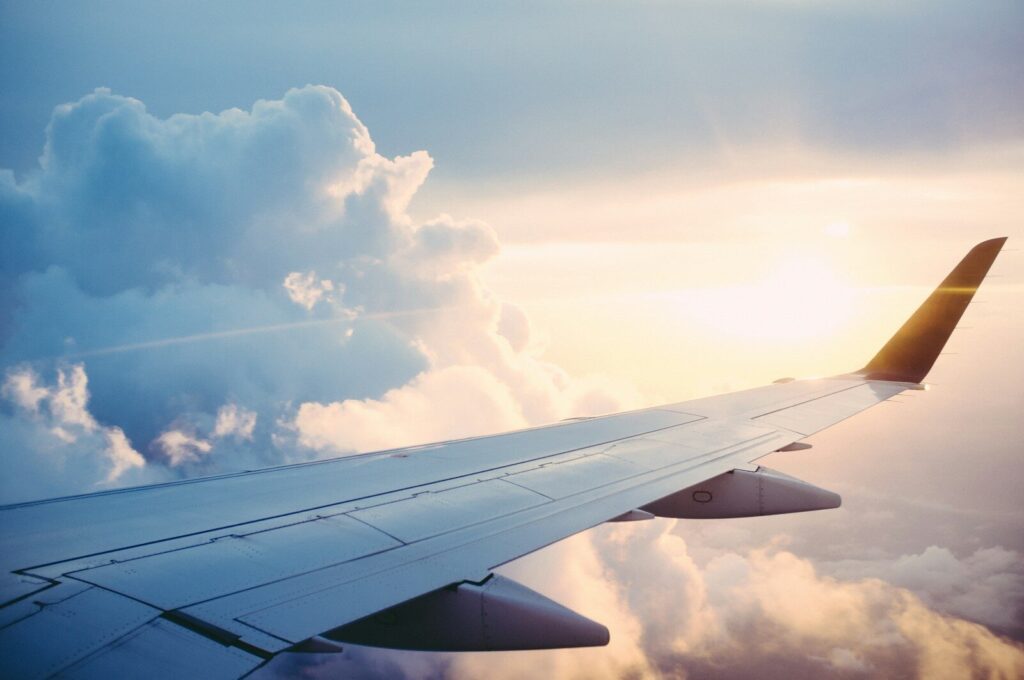 Airplane wing above clouds at sunset, symbolizing the new direct Rio de Janeiro to Lisbon flight route