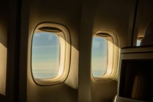 Sunlight through the windows of an airliner cabin above the clouds