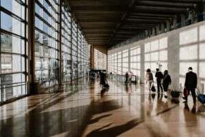 International travelers walking through a sunlit airport terminal