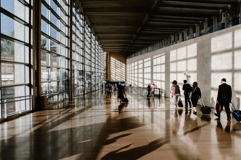 International travelers walking through a sunlit airport terminal