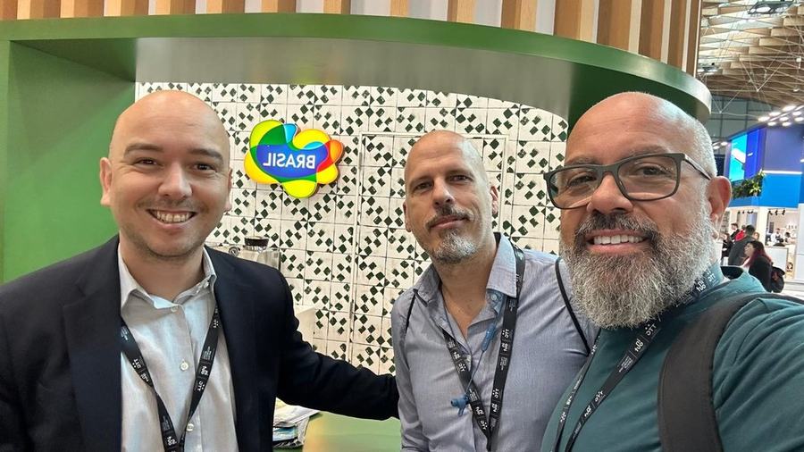 Three travel trade professionals at the Brasil pavilion counter during TTG Travel Experience in Rimini
